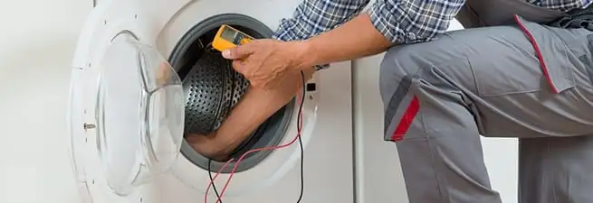 Dryer repair technician inspecting and repairing a clothes dryer in Honolulu, HI