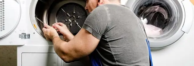Dryer repair technician fixing a clothes dryer drum in Honolulu, HI