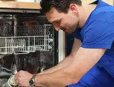 Dishwasher repair technician inspecting and servicing an open dishwasher in Honolulu, HI