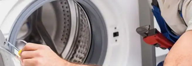Appliance technician repairing a clothes dryer drum and internal parts in Honolulu, HI