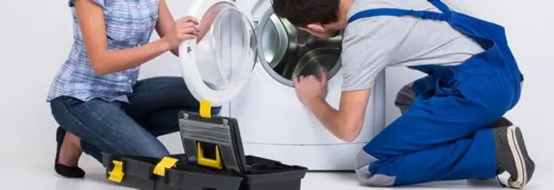 Washer repair technician inspecting a front-load washing machine with tools in Honolulu, HI
