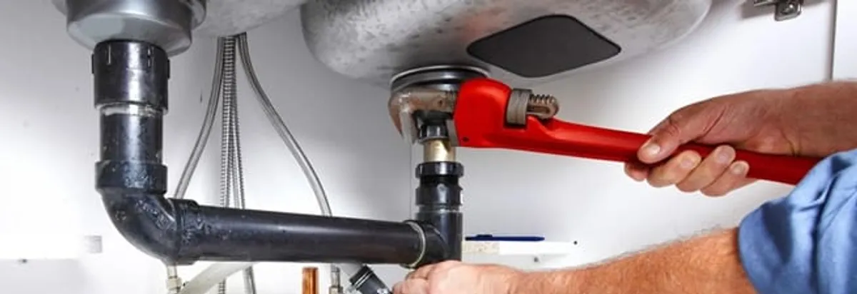 Garbage disposal repair technician tightening the sink drain and disposal connection in Honolulu, HI