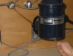 Garbage disposal repair technician tightening the mounting ring under a sink in Honolulu, HI