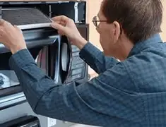 Appliance repair technician replacing a microwave vent filter in Honolulu, HI