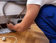 Appliance repair technician fixing refrigerator water line and connections in Honolulu, HI