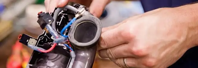 Vacuum repair technician reconnecting wiring and components in Honolulu, HI