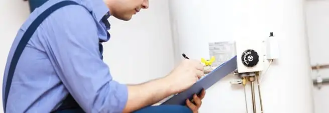 Water heater repair technician inspecting the unit and recording service notes in Honolulu, HI