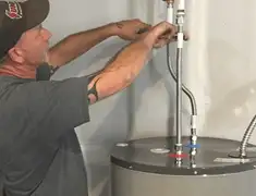Water heater repair technician tightening supply line connections in Honolulu, HI