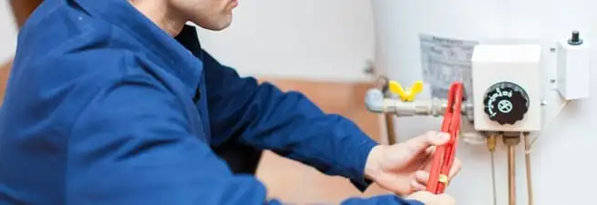Water heater repair technician adjusting the temperature control and gas valve in Honolulu, HI